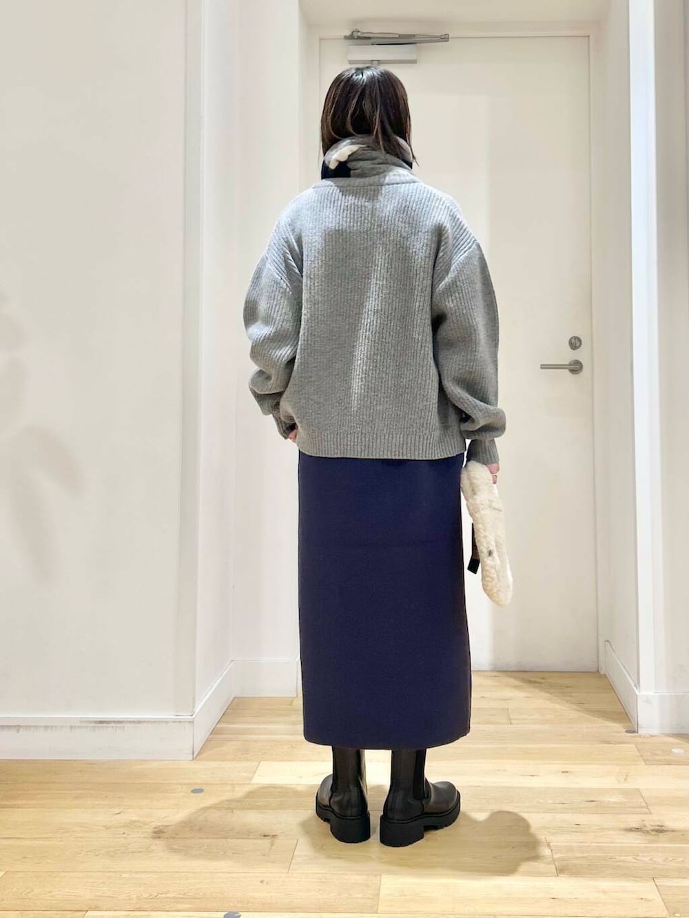 グレー系のカーディガン/ボレロ、ブラック系のブーツ、ベージュ系のハンドバッグを着用したレディースの冬コーディネートの4枚目の写真