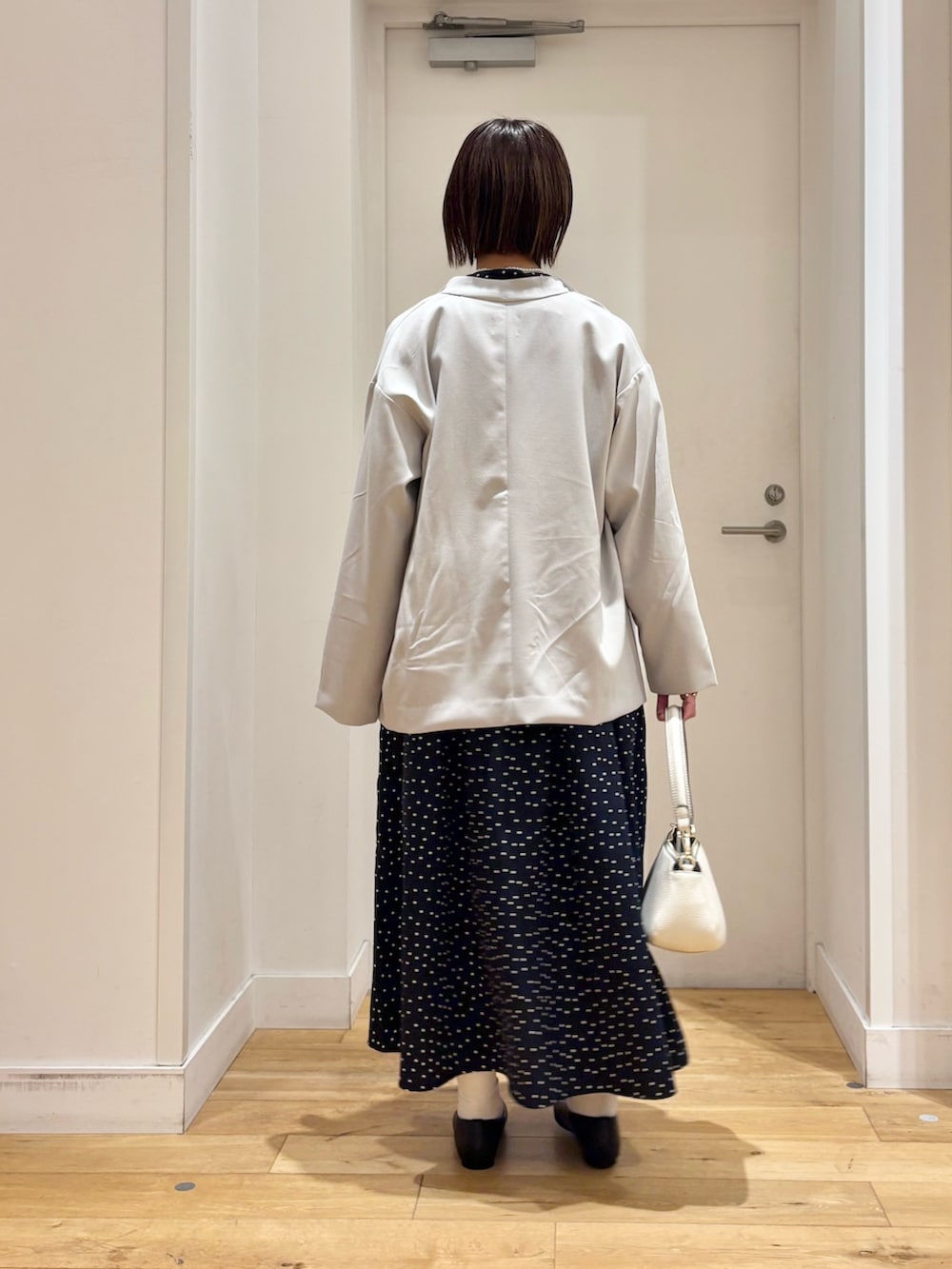 ブルー系のワンピース、グレー系のその他アウター、ホワイト系のショルダーバッグを着用したレディースの冬コーディネートの5枚目の写真