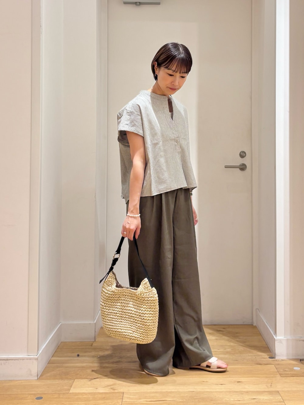 ブラック系のシャツ/ブラウス、グリーン系のその他パンツ、ベージュ系のトートバッグを着用したレディースの夏コーディネートの4枚目の写真