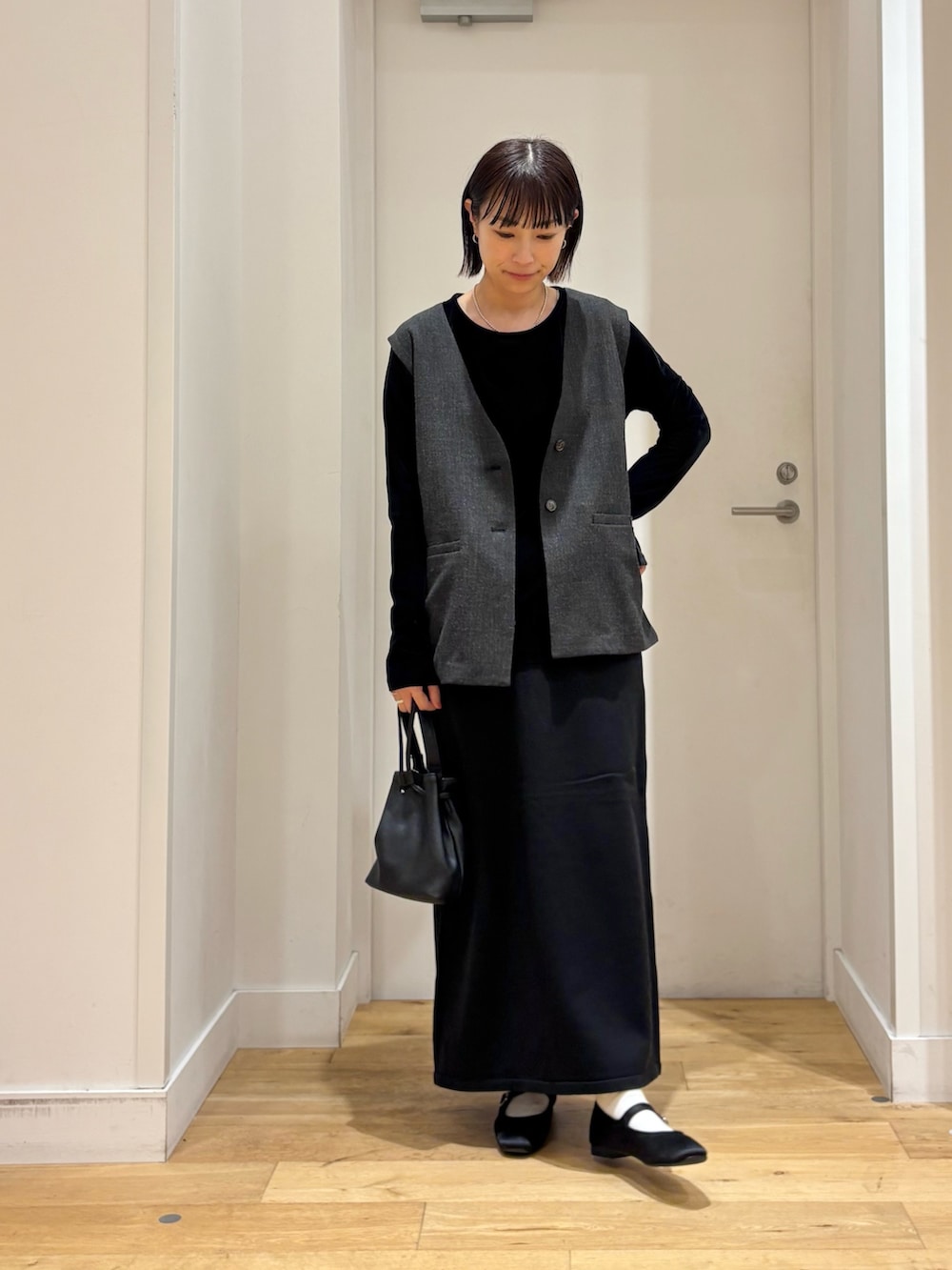 ブラック系のショルダーバッグ、ブラック系のTシャツ/カットソー、ブラック系のその他アウターを着用したレディースの秋コーディネートの2枚目の写真