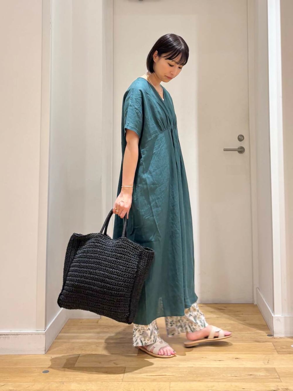 ブラック系のトートバッグ、ホワイト系のサンダル、ベージュ系のその他パンツを着用したレディースの夏コーディネートの5枚目の写真