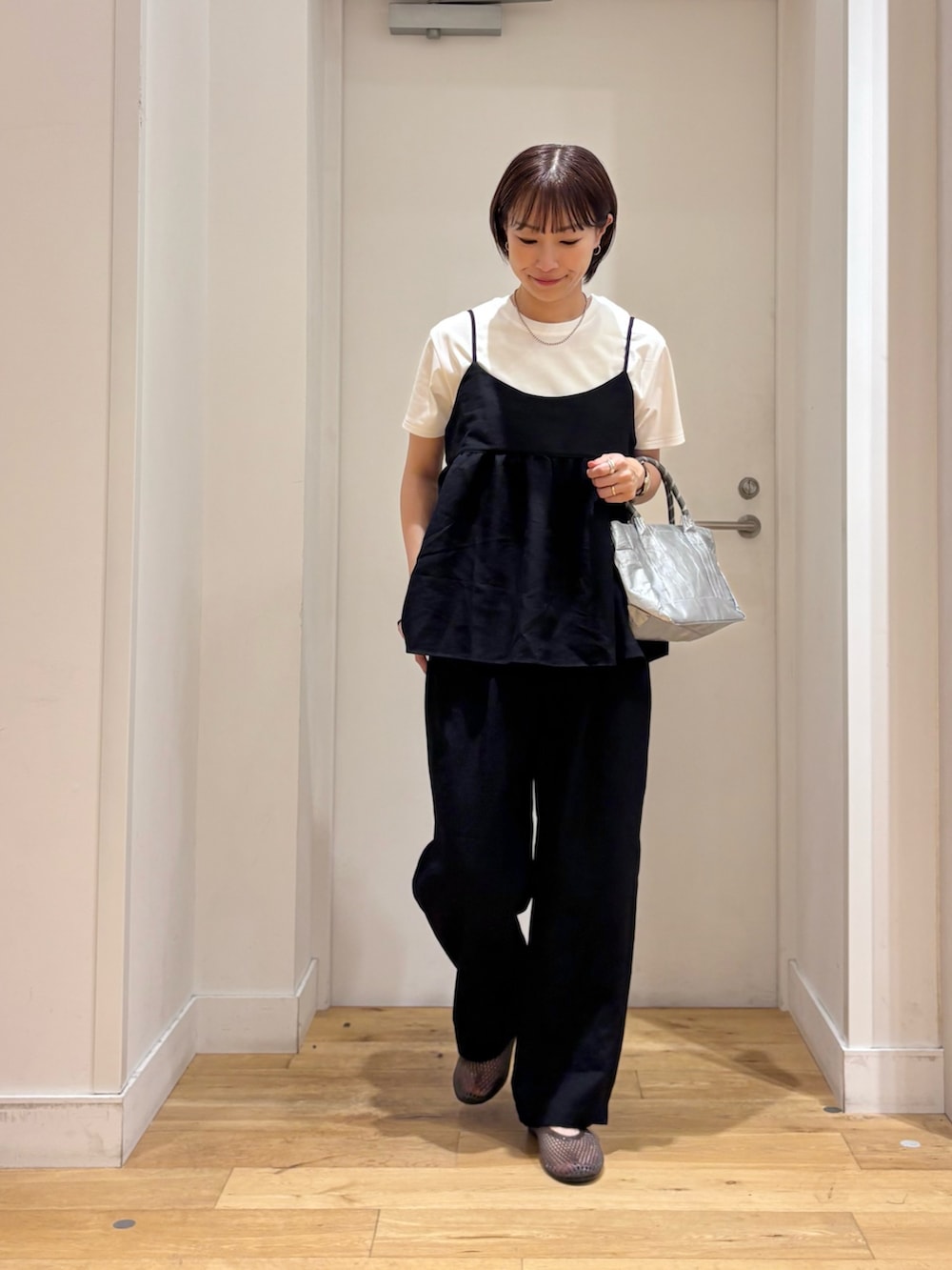 ブラック系のワンピース、ホワイト系のTシャツ/カットソー、シルバー系のショルダーバッグを着用したレディースの夏コーディネートの3枚目の写真