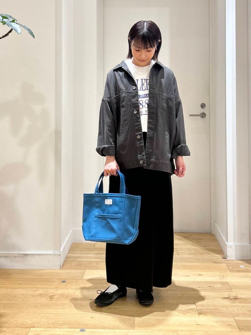 ホワイト系のTシャツ/カットソー、ブラック系のバレエシューズ、グレー系のブルゾンを着用したレディースの秋コーディネートの3枚目の写真