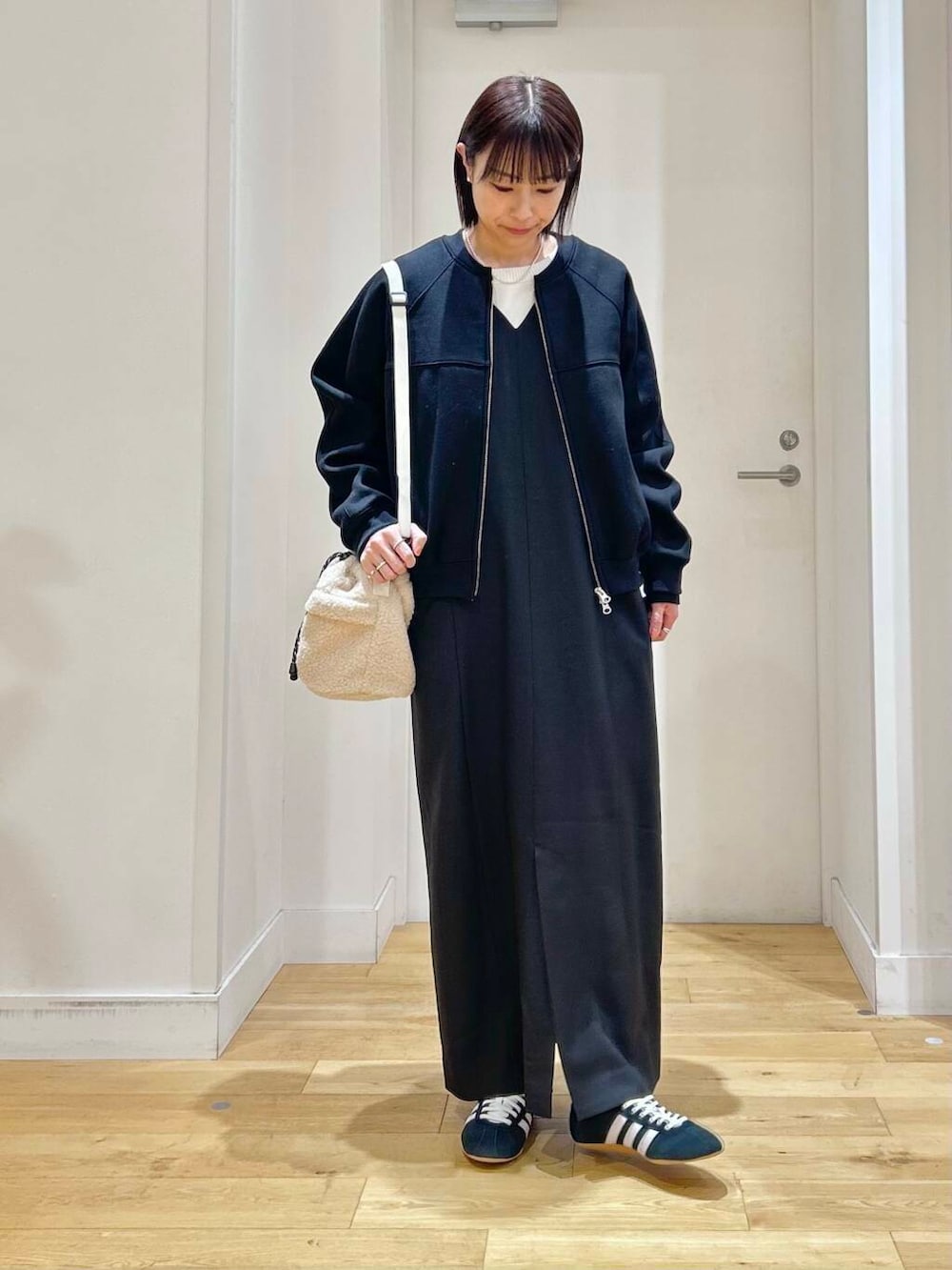 ブラック系のニット/セーター、ブラック系のワンピース、ブラック系のカーディガン/ボレロを着用したレディースの冬コーディネートの2枚目の写真