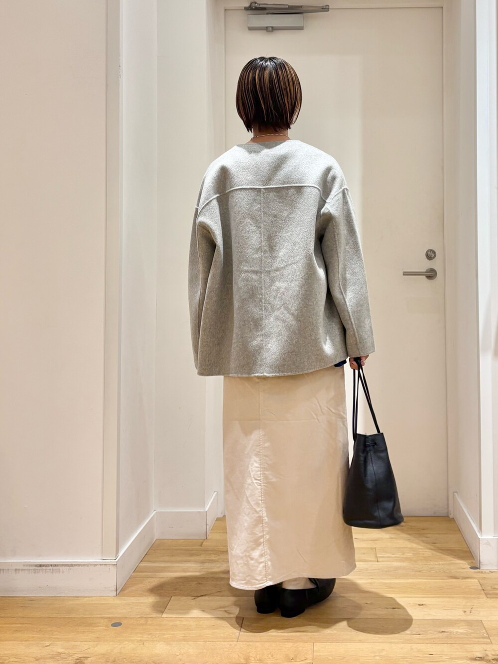 グレー系のその他アウター、ブルー系のニット/セーター、ブラック系のショルダーバッグを着用したレディースの秋コーディネートの4枚目の写真