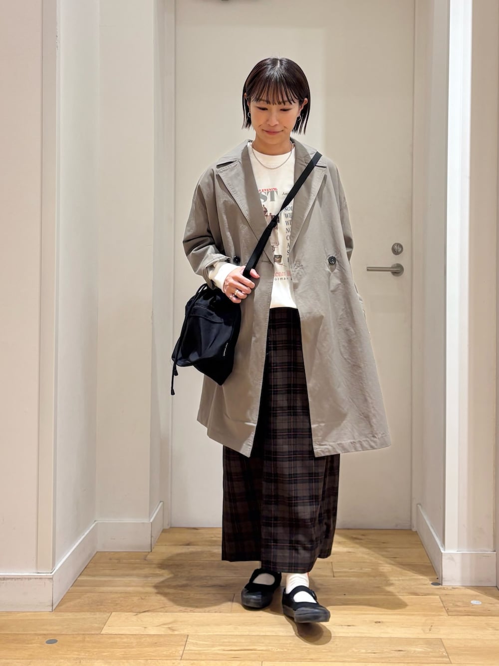 ホワイト系のTシャツ/カットソー、ベージュ系のスカート、ブラック系のショルダーバッグを着用したレディースの冬コーディネートの3枚目の写真