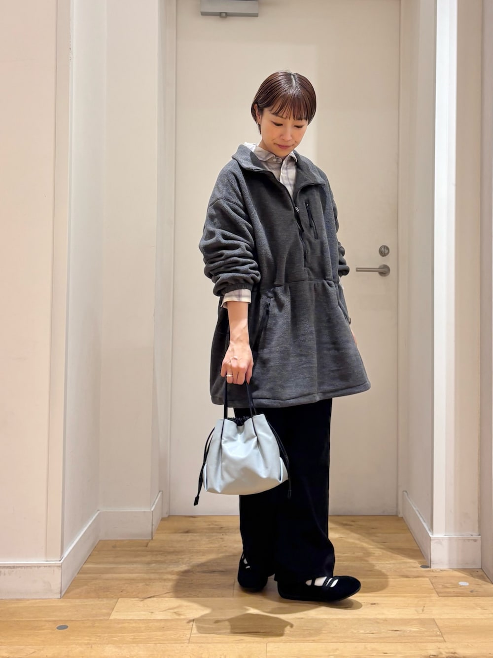 グレー系のスウェット、ブラック系のデニムパンツ、ホワイト系のシャツ/ブラウスを着用したレディースの秋コーディネートの5枚目の写真