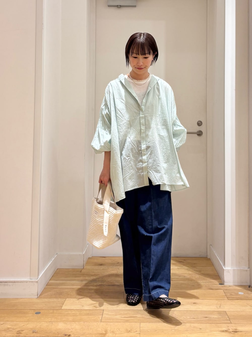 グリーン系のシャツ/ブラウス、ホワイト系のTシャツ/カットソー、ブルー系のデニムパンツを着用したレディースの春コーディネートの2枚目の写真