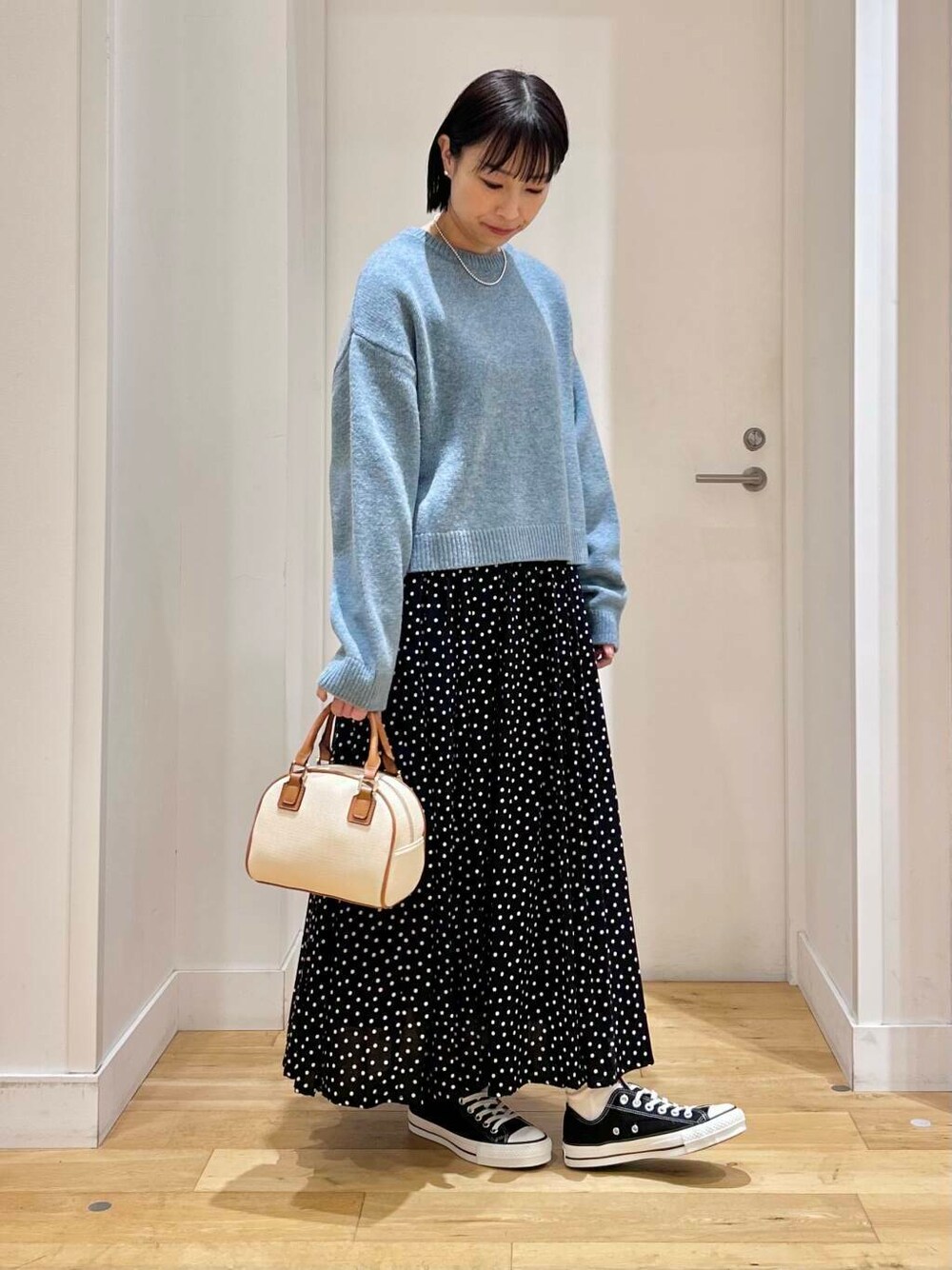 ブラック系のスニーカー、ブルー系のニット/セーター、イエロー系のボストンバッグを着用したレディースの冬コーディネートの4枚目の写真