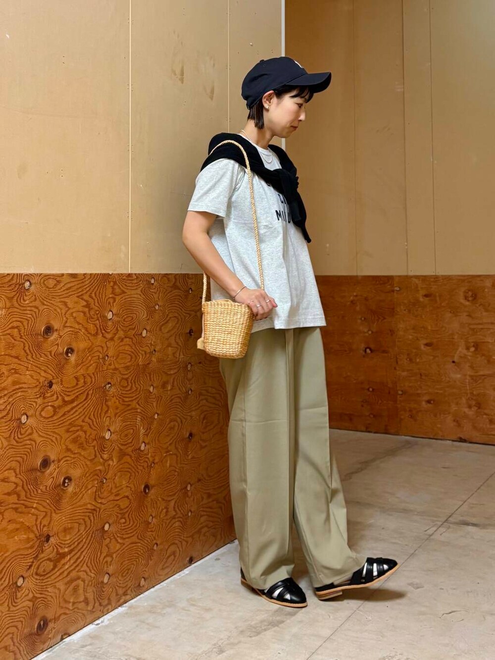 ブラック系のカーディガン/ボレロ、ブラック系のサンダル、ベージュ系のショルダーバッグを着用したレディースの春コーディネートの4枚目の写真