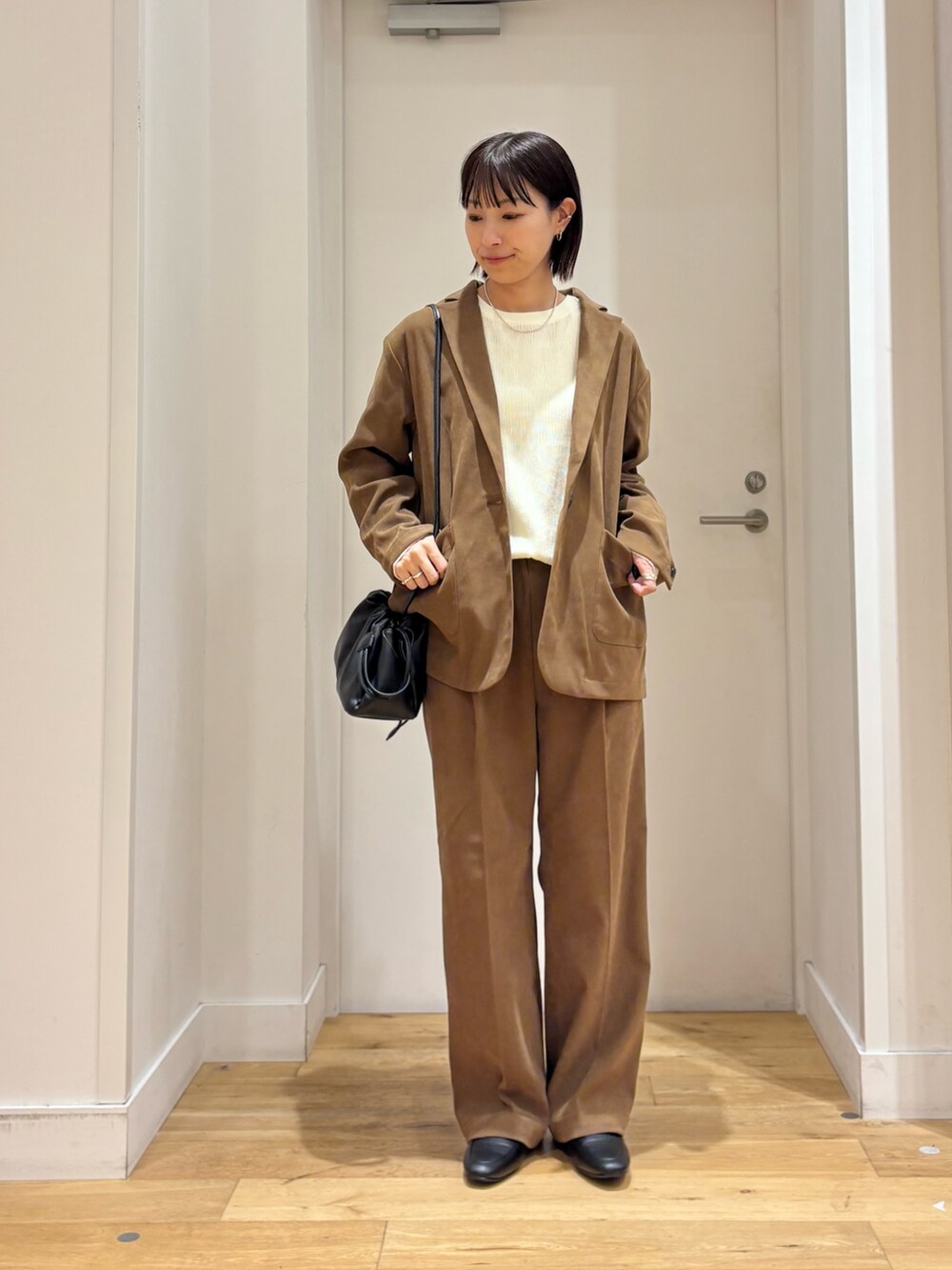 ベージュ系のその他アウター、ホワイト系のTシャツ/カットソー、ベージュ系のその他パンツを着用したレディースの秋コーディネートの3枚目の写真