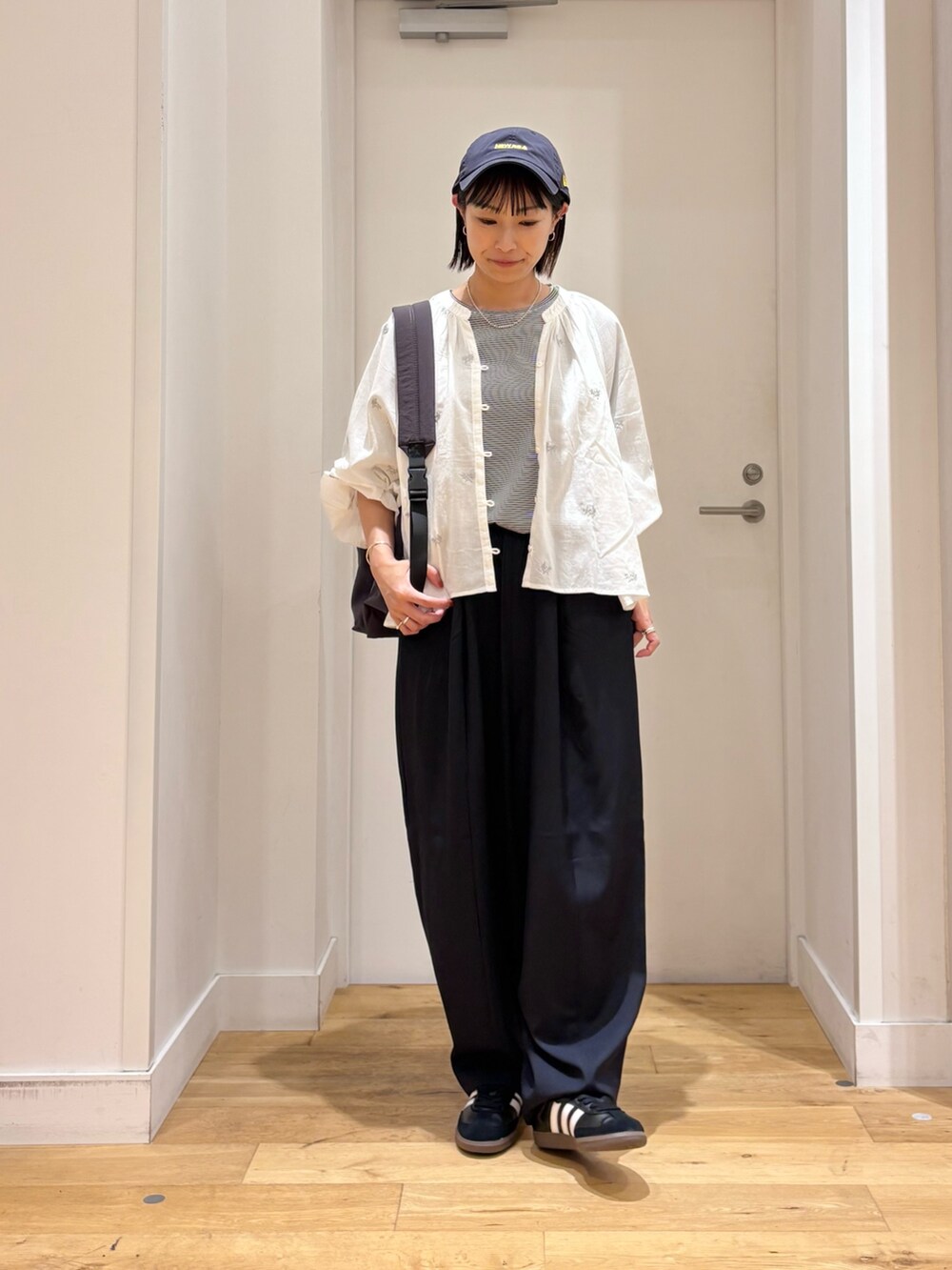 グレー系のバックパック/リュック、ホワイト系のシャツ/ブラウス、ブルー系のその他パンツを着用したレディースの秋コーディネートの4枚目の写真