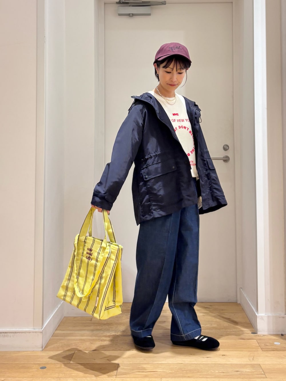 ブルー系のマウンテンパーカー、ホワイト系のTシャツ/カットソー、イエロー系のトートバッグを着用したレディースの春コーディネートの5枚目の写真