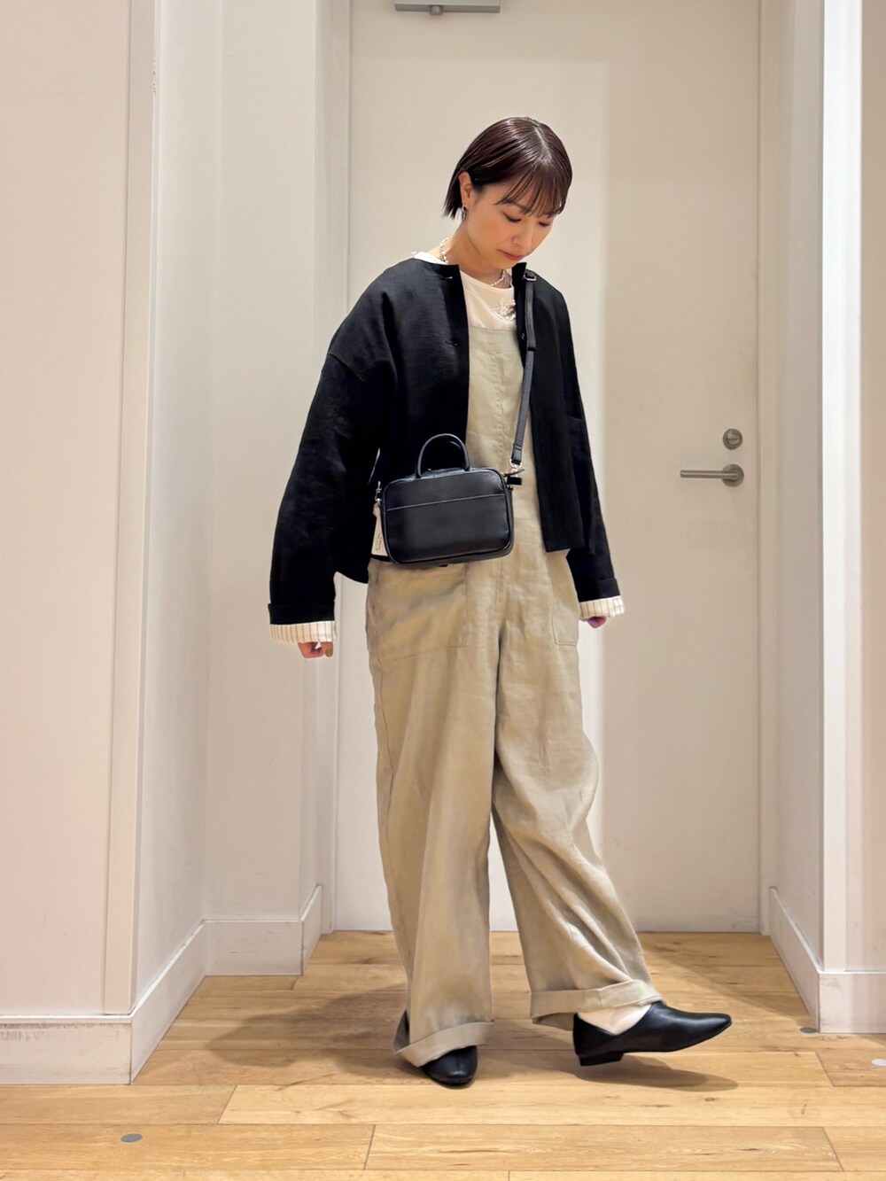 ホワイト系のシャツ/ブラウス、グレー系のサロペット/オーバーオール、ブラック系のその他シューズを着用したレディースの春コーディネートの5枚目の写真