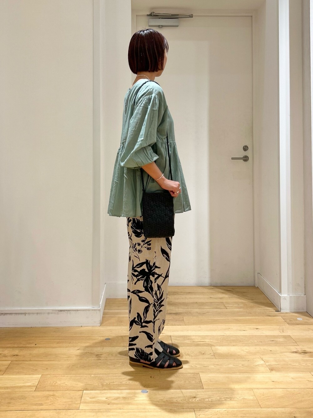 グリーン系のシャツ/ブラウス、ベージュ系のその他パンツ、ブラック系のサンダルを着用したレディースの春コーディネートの2枚目の写真