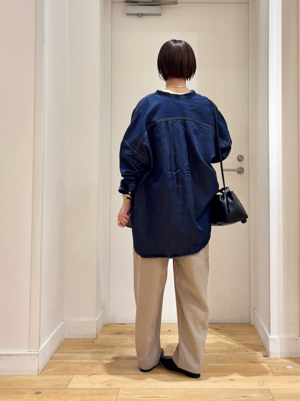 ブルー系のシャツ/ブラウス、ピンク系のニット/セーター、ホワイト系のTシャツ/カットソーを着用したレディースの春コーディネートの5枚目の写真