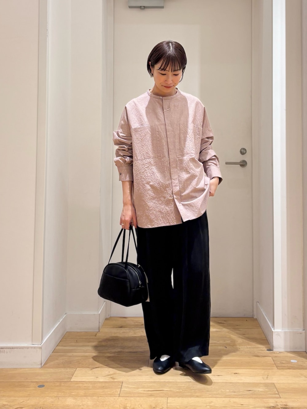 ピンク系のシャツ/ブラウス、ブラック系のその他パンツ、ブラック系のボストンバッグを着用したレディースの冬コーディネートの2枚目の写真