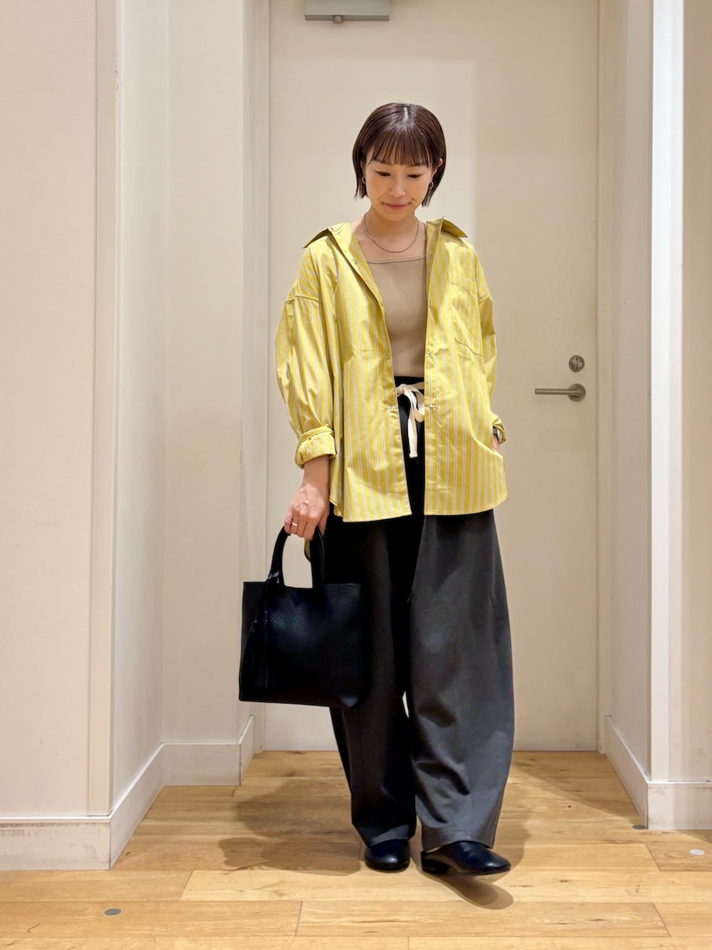 イエロー系のシャツ/ブラウス、グレー系のその他パンツ、ベージュ系のタンクトップを着用したレディースの夏コーディネートの2枚目の写真