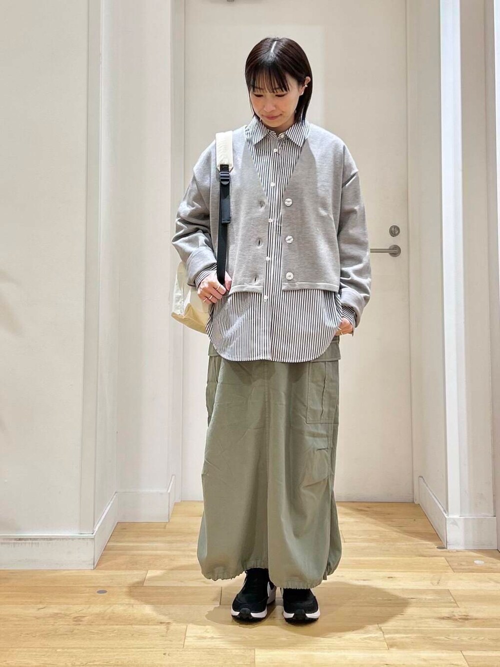 ブルー系のシャツ/ブラウス、グリーン系のスカート、ホワイト系のバックパック/リュックを着用したレディースの冬コーディネートの2枚目の写真