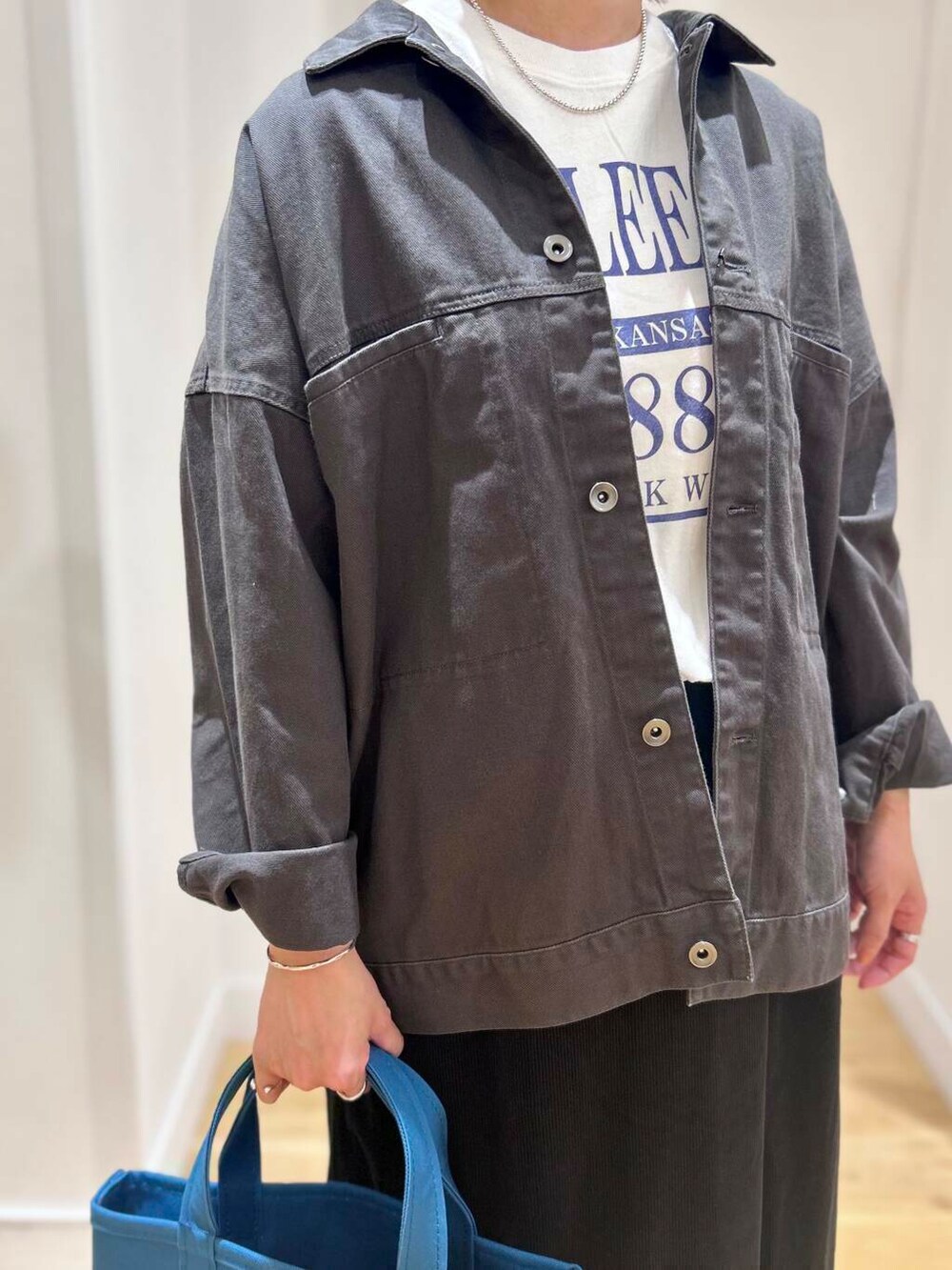 ホワイト系のTシャツ/カットソー、ブラック系のバレエシューズ、グレー系のブルゾンを着用したレディースの秋コーディネートの6枚目の写真