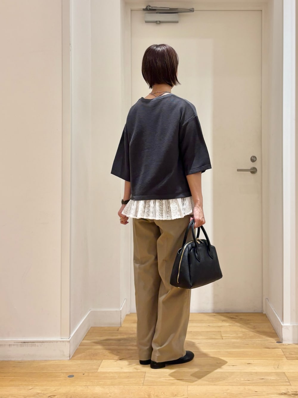 グレー系のニット/セーター、ベージュ系のその他パンツ、ブラック系のハンドバッグを着用したレディースの秋コーディネートの6枚目の写真