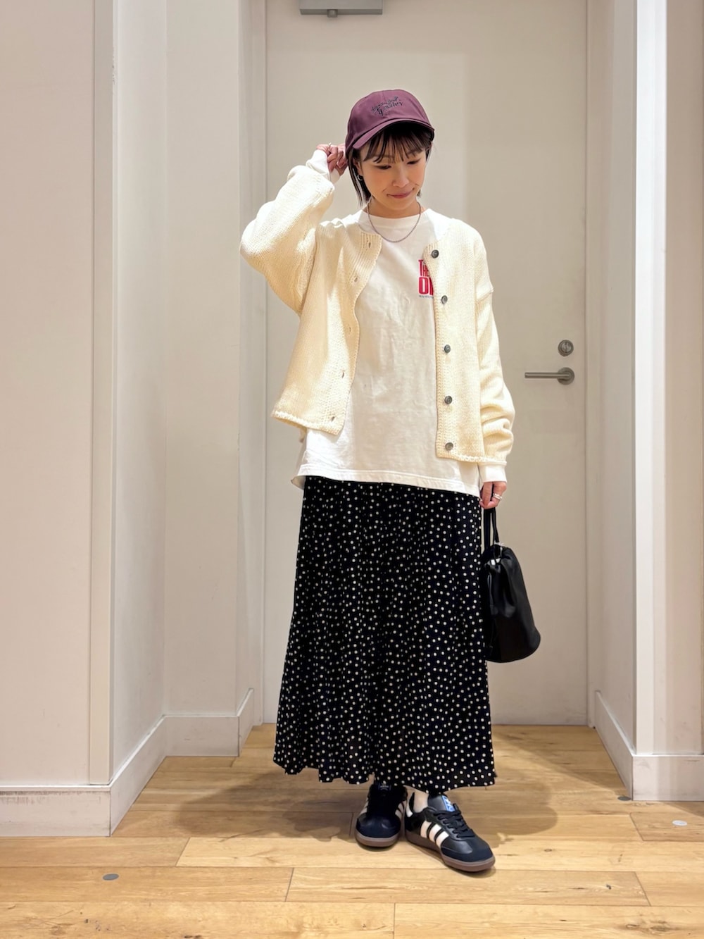 ホワイト系のカーディガン/ボレロ、ブラック系のバッグ、ブラック系のスカートを着用したレディースの冬コーディネートの4枚目の写真