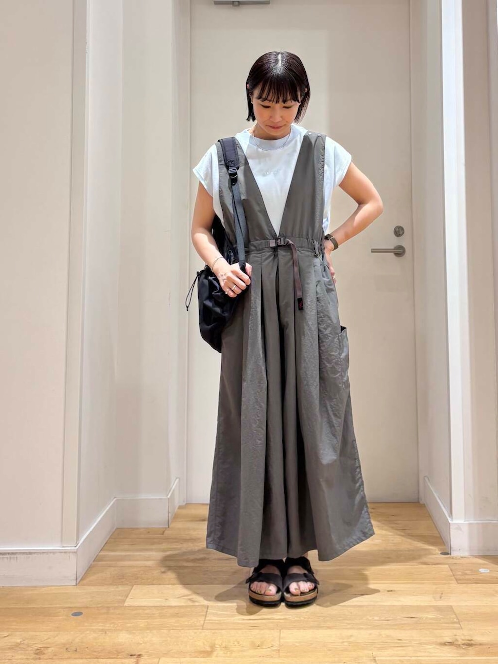 グレー系のサロペット/オーバーオール、ブラック系のバックパック/リュック、ブルー系のTシャツ/カットソーを着用したレディースの夏コーディネートの2枚目の写真