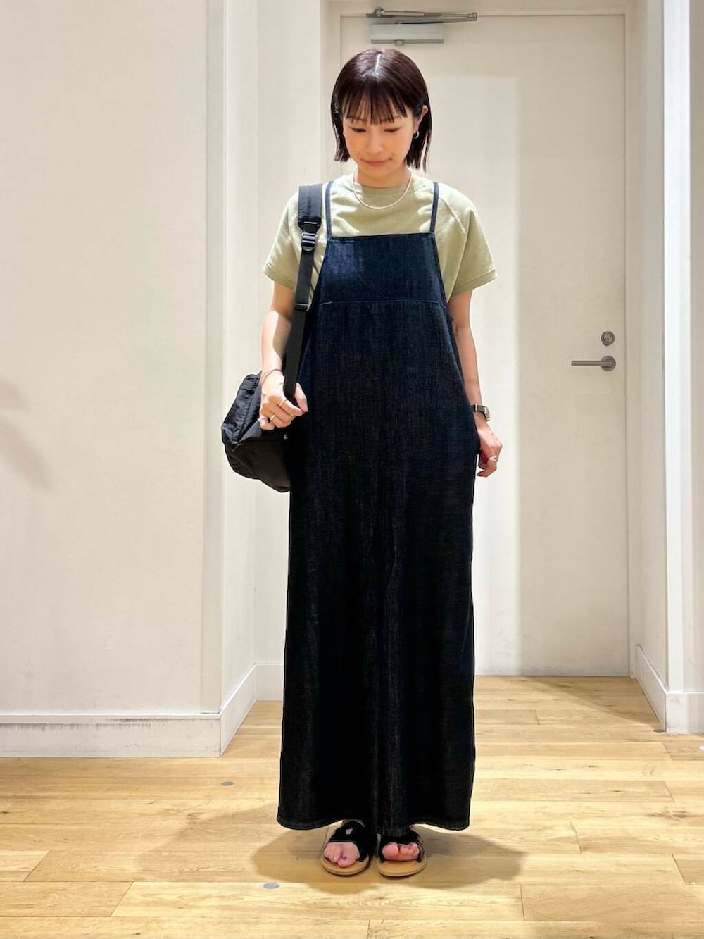 ブラック系のサンダル、ブルー系のワンピース、ブラック系のバックパック/リュックを着用したレディースの夏コーディネートの2枚目の写真