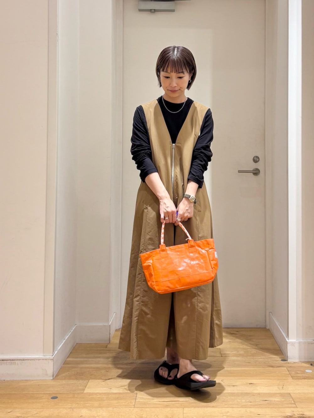 ブラック系のTシャツ/カットソー、ベージュ系のワンピース、オレンジ系のショルダーバッグを着用したレディースの夏コーディネートの3枚目の写真