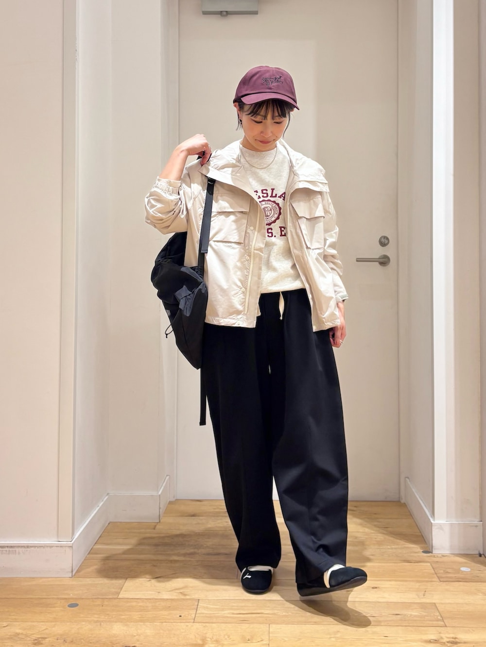 ホワイト系のナイロンジャケット、ブラック系のその他パンツ、ブラック系のスニーカーを着用したレディースの春コーディネートの4枚目の写真