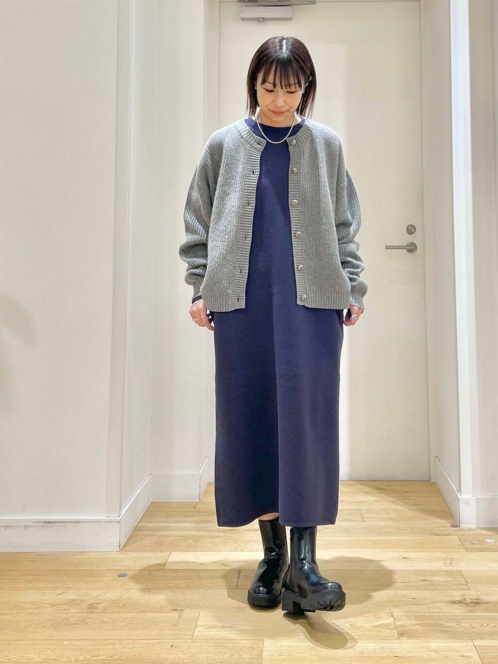 グレー系のカーディガン/ボレロ、ブラック系のブーツ、ベージュ系のハンドバッグを着用したレディースの冬コーディネートの5枚目の写真