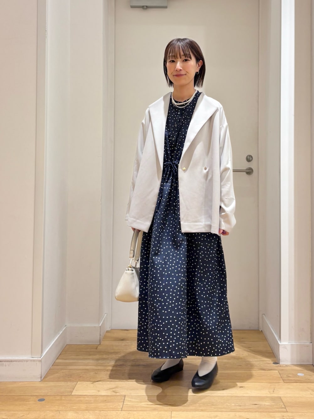 ブルー系のワンピース、グレー系のその他アウター、ホワイト系のショルダーバッグを着用したレディースの冬コーディネートの4枚目の写真