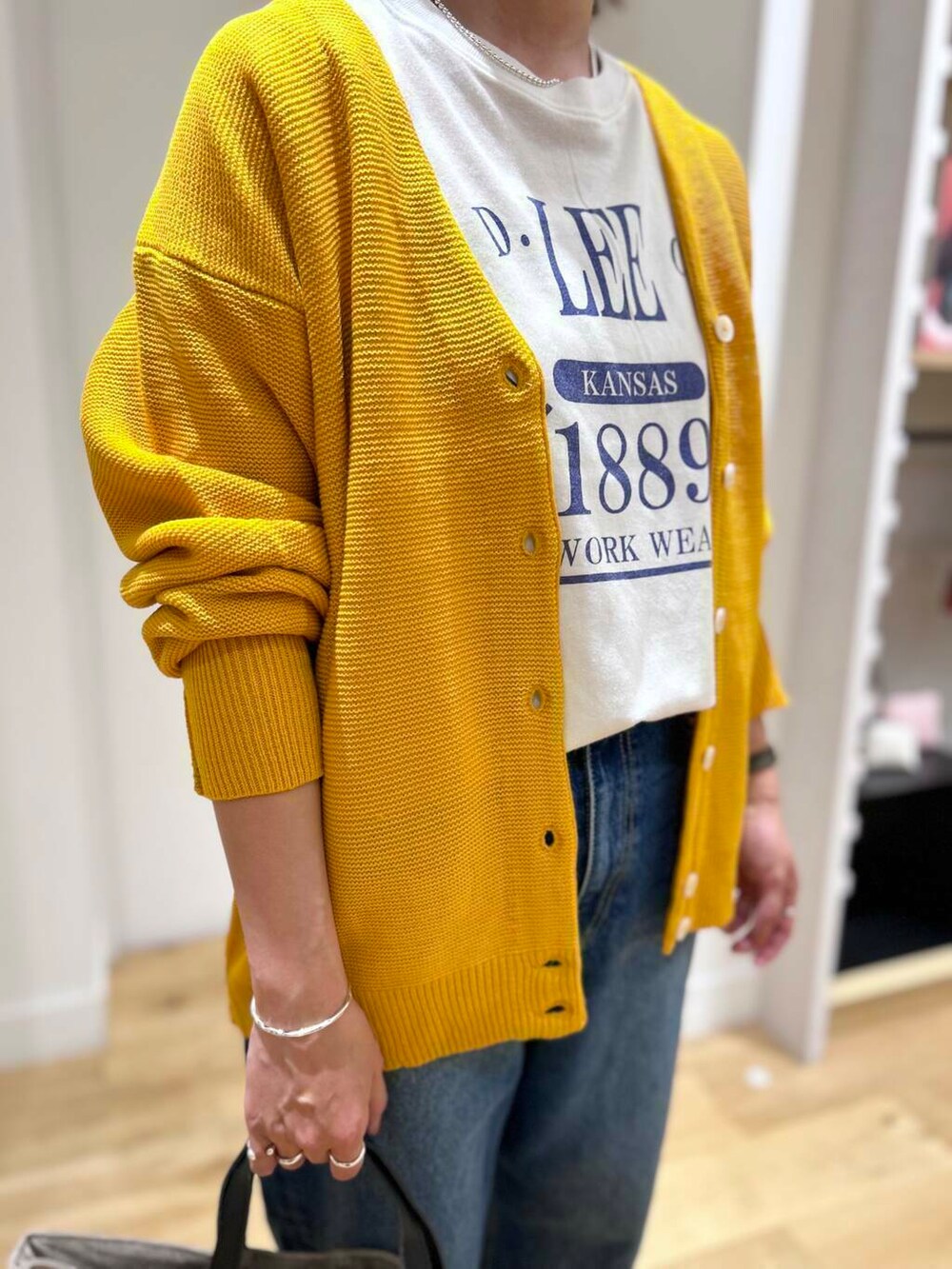 ホワイト系のTシャツ/カットソー、ブラック系のスニーカー、ベージュ系のトートバッグを着用したレディースの秋コーディネートの5枚目の写真