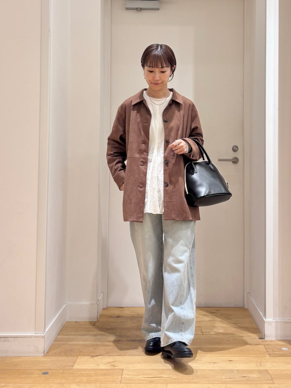 ブラウン系のテーラードジャケット、ホワイト系のシャツ/ブラウス、ブルー系のデニムパンツを着用したレディースの秋コーディネートの4枚目の写真