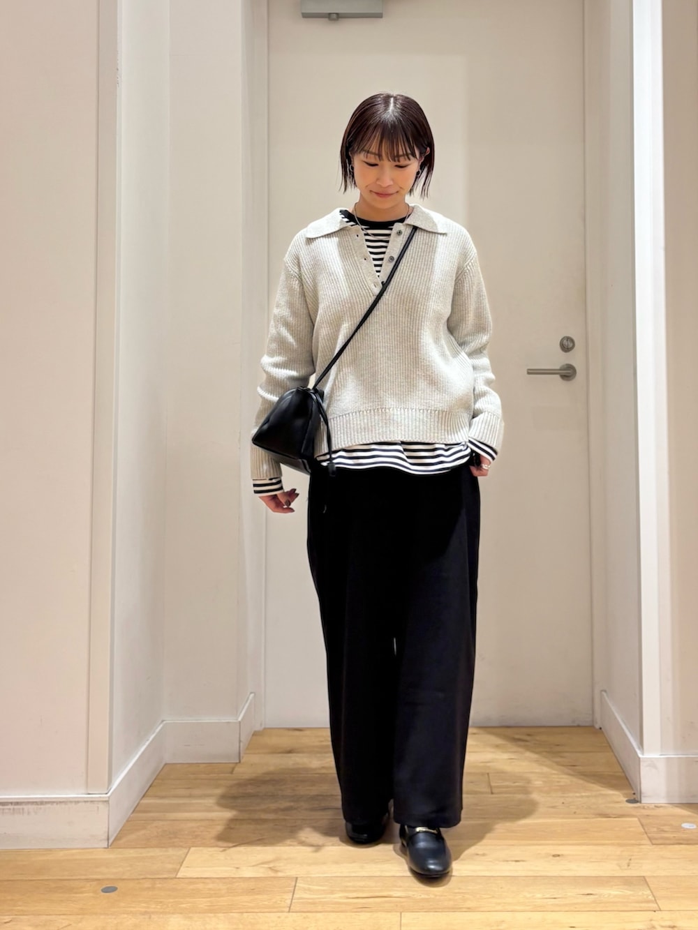 グレー系のニット/セーター、ホワイト系のTシャツ/カットソー、ブラック系のその他パンツを着用したレディースの冬コーディネートの2枚目の写真