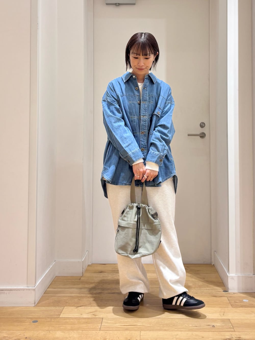 グレー系のその他パンツ、ブルー系のショルダーバッグ、ブラック系のスニーカーを着用したレディースの冬コーディネートの3枚目の写真