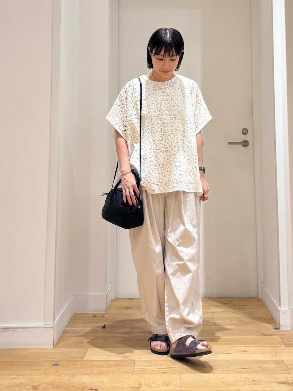 グレー系のその他パンツ、グレー系のサンダル、ホワイト系のTシャツ/カットソーを着用したレディースの夏コーディネートの2枚目の写真