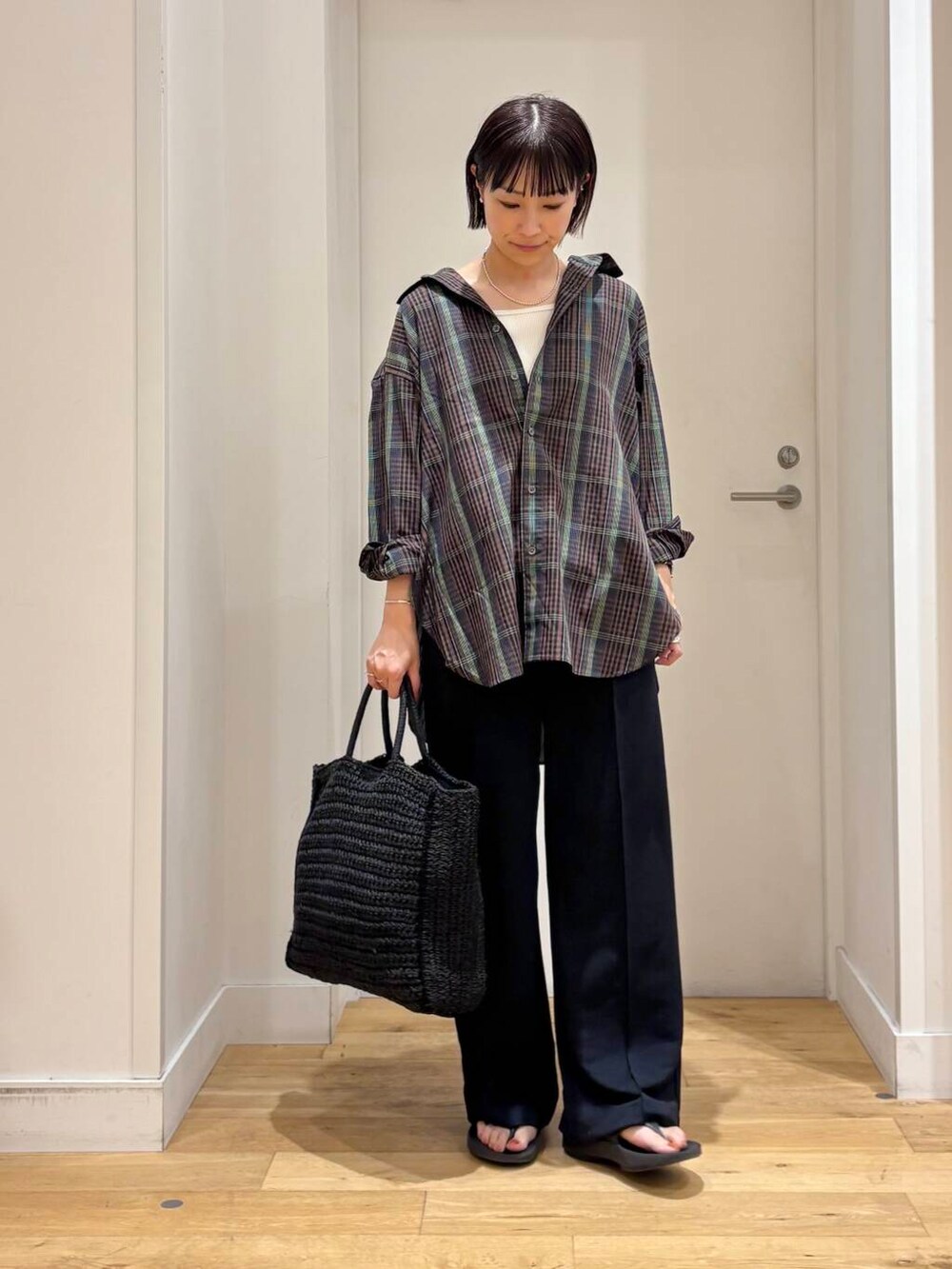 ブラック系のトートバッグ、ブラック系のサンダル、ブラウン系のシャツ/ブラウスを着用したレディースの夏コーディネートの3枚目の写真