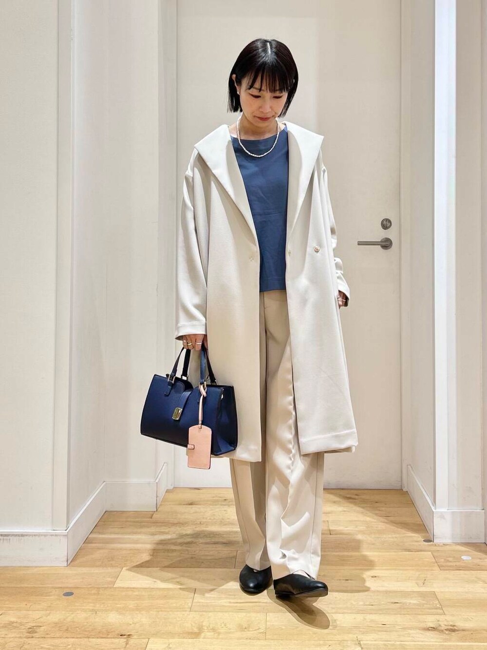 ブルー系のTシャツ/カットソー、ホワイト系のその他パンツ、ブラック系のパンプスを着用したレディースの冬コーディネートの2枚目の写真