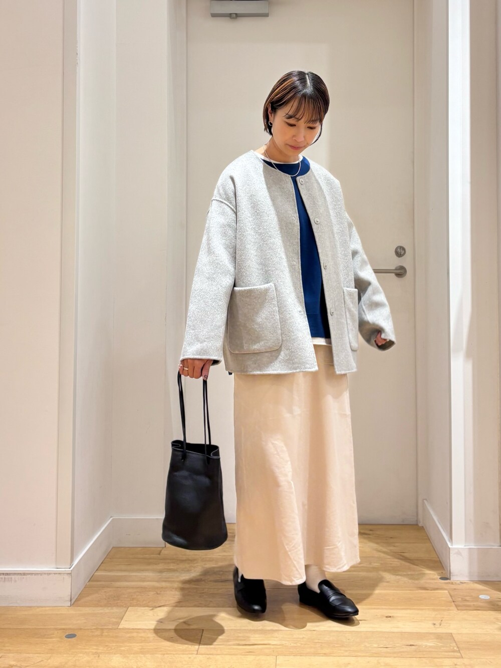 グレー系のその他アウター、ブルー系のニット/セーター、ブラック系のショルダーバッグを着用したレディースの秋コーディネートの3枚目の写真