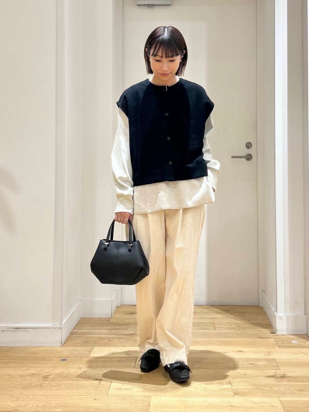 ブラック系のドレスシューズ、ベージュ系のデニムパンツ、ブラック系のショルダーバッグを着用したレディースの冬コーディネートの3枚目の写真