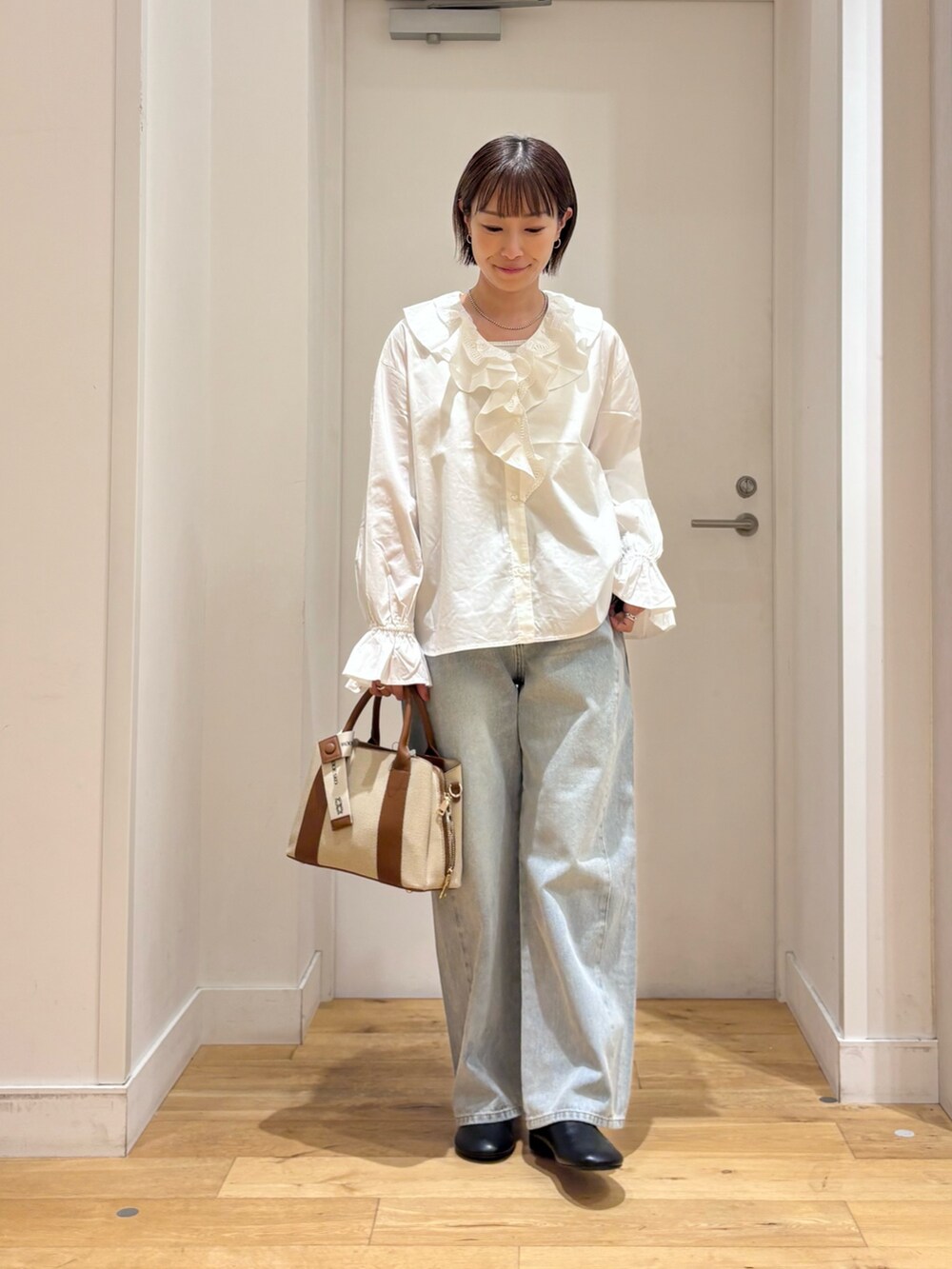 ホワイト系のシャツ/ブラウス、ブルー系のデニムパンツ、ブラック系のその他シューズを着用したレディースの秋コーディネートの2枚目の写真
