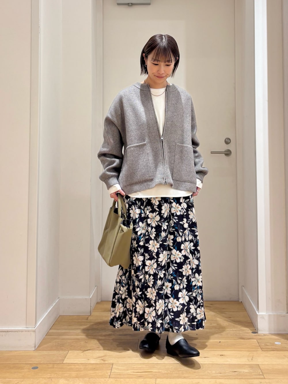 グリーン系のニット/セーター、ホワイト系のTシャツ/カットソー、ブルー系のスカートを着用したレディースの冬コーディネートの3枚目の写真