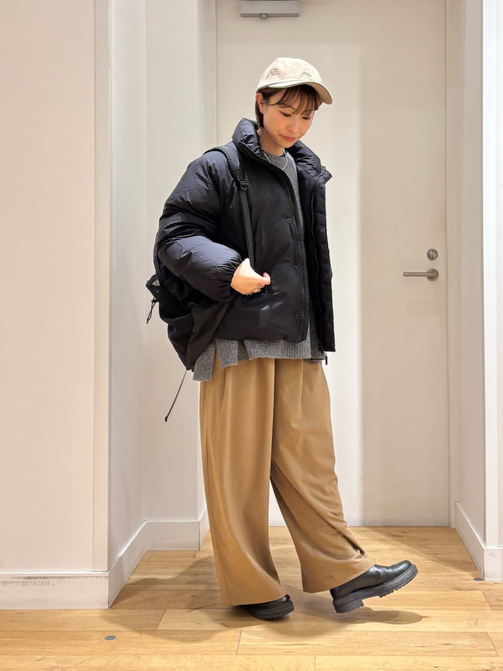 ベージュ系のその他パンツ、グレー系のニット/セーター、ブラック系のダウンジャケット/コートを着用したレディースの秋コーディネートの4枚目の写真