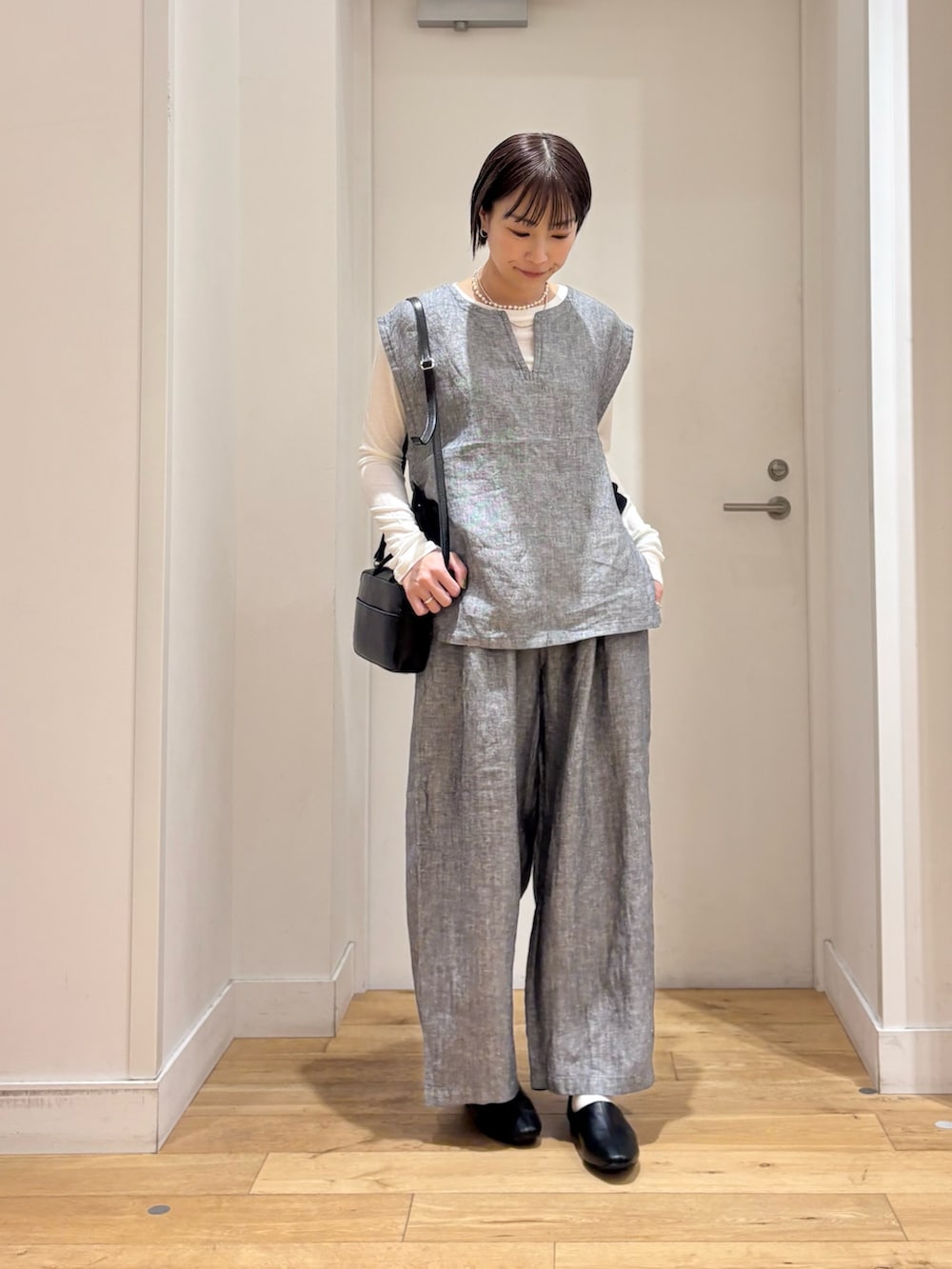 ホワイト系のTシャツ/カットソー、グレー系のベスト、グレー系のその他パンツを着用したレディースの春コーディネートの2枚目の写真