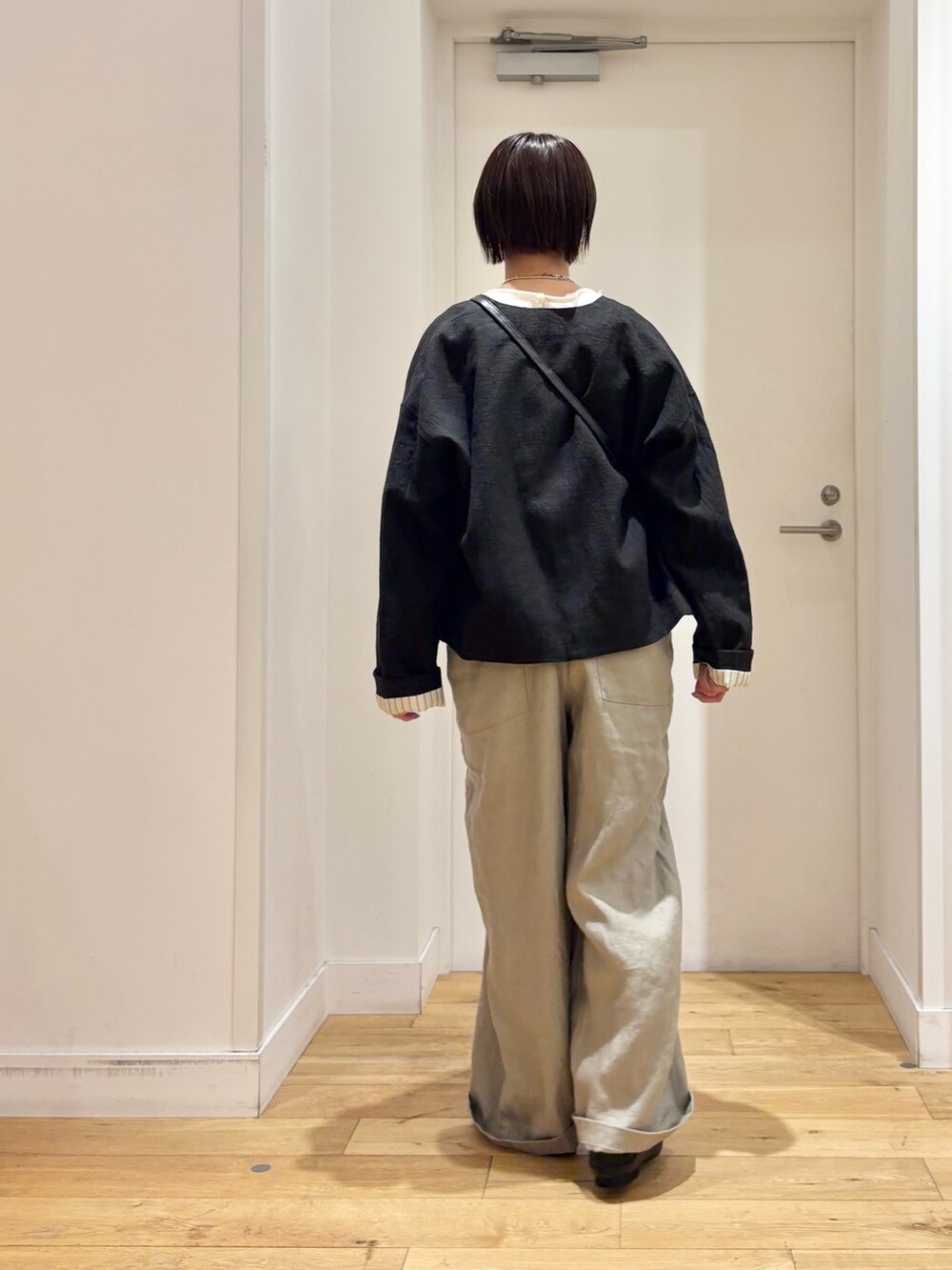 ホワイト系のシャツ/ブラウス、グレー系のサロペット/オーバーオール、ブラック系のその他シューズを着用したレディースの春コーディネートの6枚目の写真