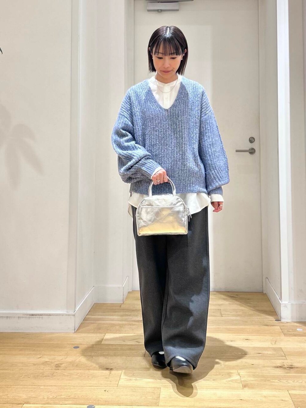 ブラック系のパンプス、ホワイト系のシャツ/ブラウス、グレー系のその他パンツを着用したレディースの冬コーディネートの2枚目の写真