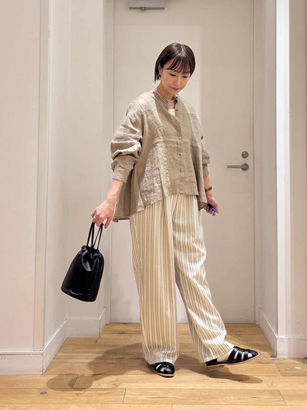 ブラウン系のシャツ/ブラウス、ホワイト系のタンクトップ、ベージュ系のその他パンツを着用したレディースの春コーディネートの5枚目の写真