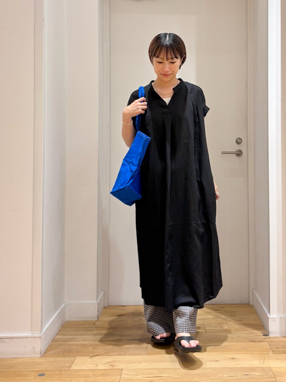 ブラック系のその他パンツ、ブラック系のサンダル、ホワイト系のタンクトップを着用したレディースの夏コーディネートの4枚目の写真