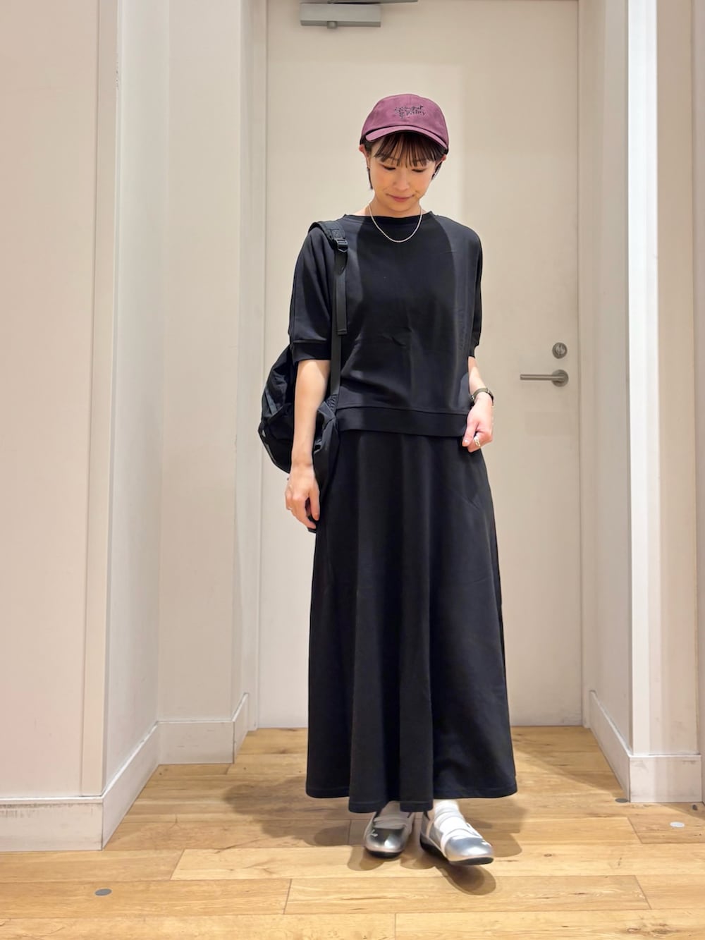 ブラック系のTシャツ/カットソー、ブラック系のバックパック/リュック、シルバー系のスニーカーを着用したレディースの春コーディネートの4枚目の写真